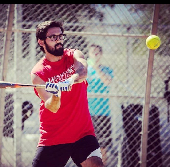 man hitting a softball at a softball league game