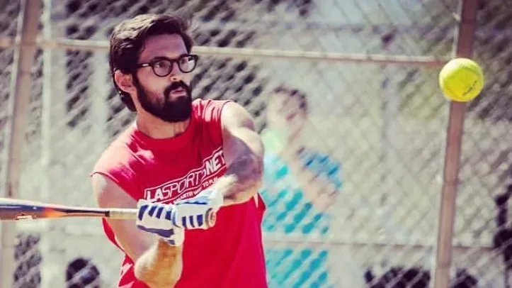 A young man playing softball during an adult softball league in Los Angeles, California.