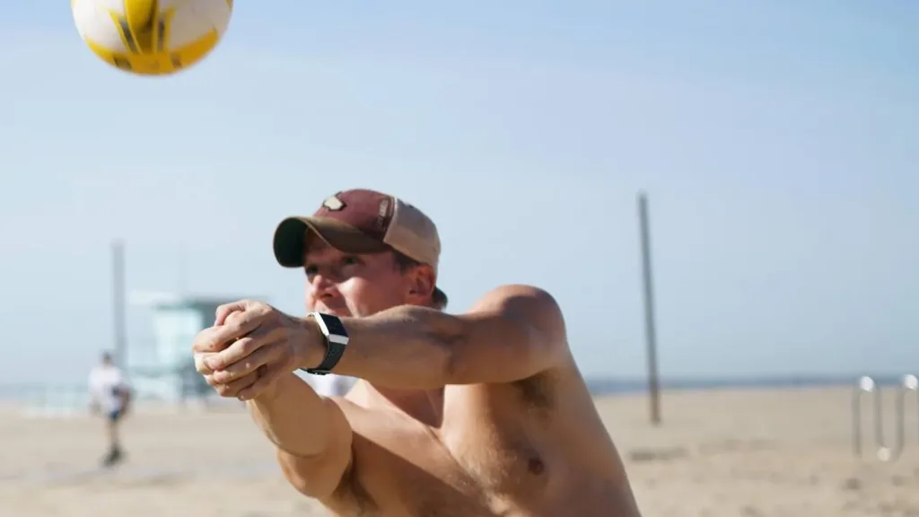 A young man playing beach volleyball during an adult volleyball league in Los Angeles, California.