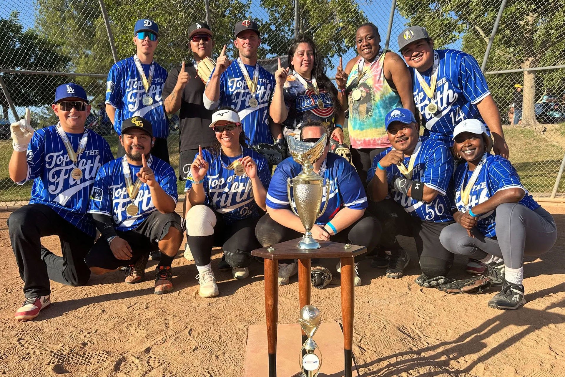 A group of an adult sports league in los angeles smiling at the camera after winning the league finals